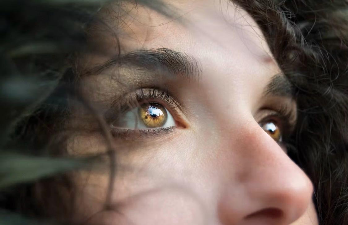 Close-up of a golden eye with dark tinted lashes