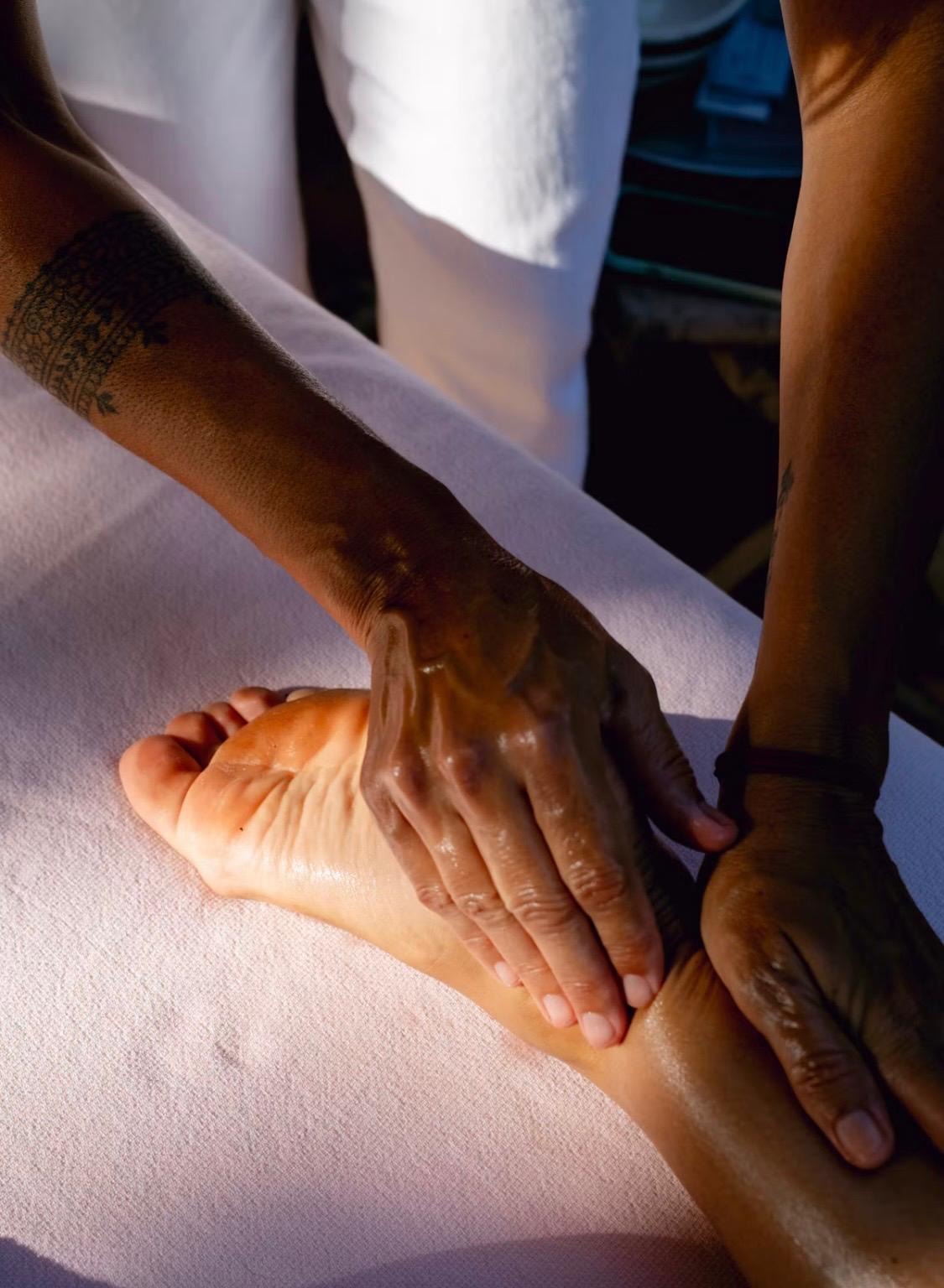 Therapist's hands working on the sole of a foot