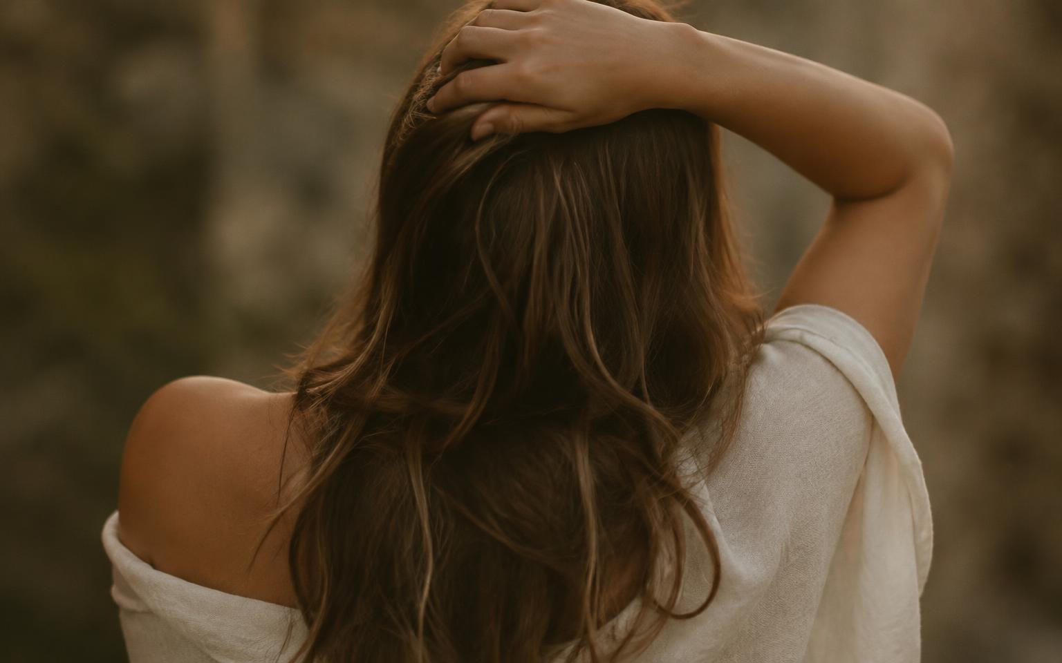 Woman from behind with one arm raised